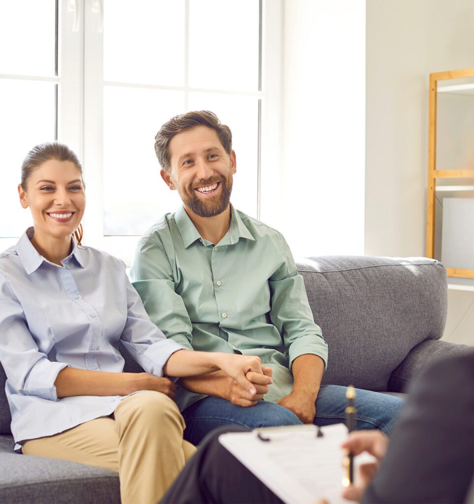 A beaming couple holding hands and smiling together during a couples intensive therapy session in Las Vegas, NV, reflecting the joy, renewed connection, and relationship breakthroughs achieved through an accelerated marriage intensive retreat with Dr. Belle