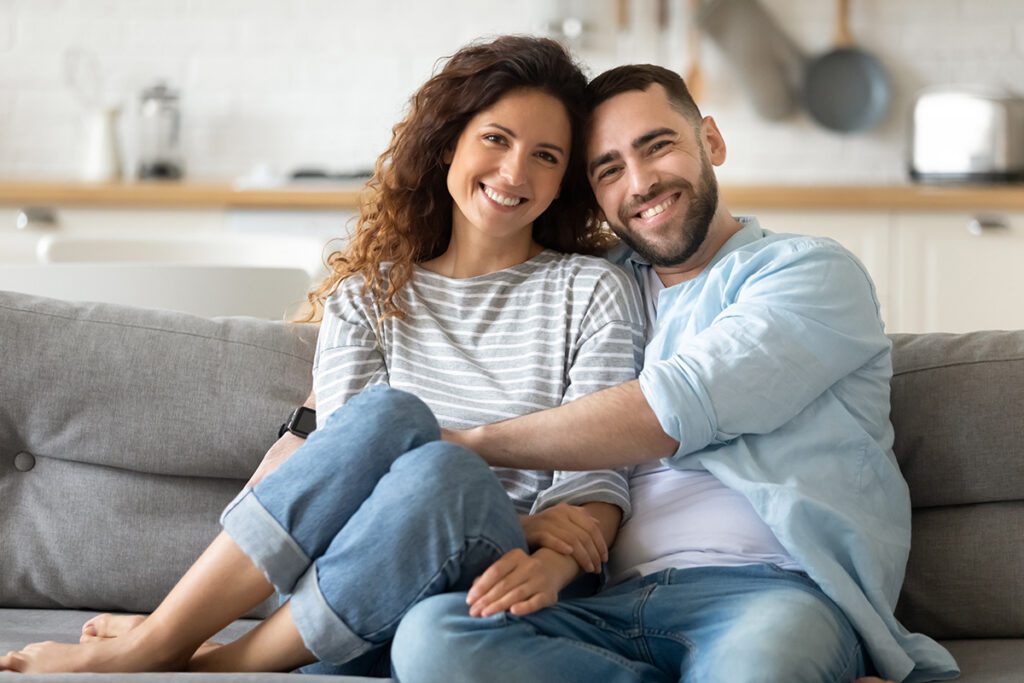 Happy couple smiling and embracing at home after successful couples therapy in Las Vegas using Emotionally Focused Therapy